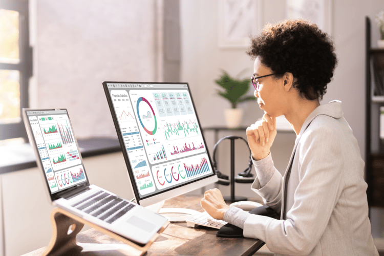 woman looking at computer with financial growth charts on screen woman looking at computer with financial growth charts on screen