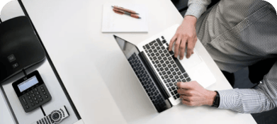 A man in a gray shirt works on his macbook